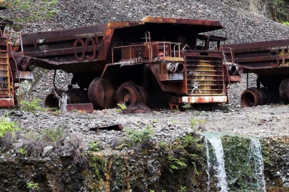 Heavy trucks sit rusting on the edges of Panguna copper mine, closed in 1989 as a result of sabotage.