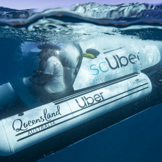 The ride-share submarine scUber, seen submerging near the shipwreck of HMAS Protector in the Great Barrier Reef.