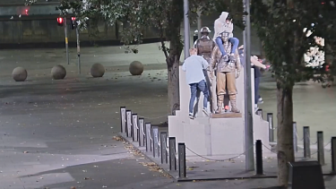 A group of young men have been caught on CCTV climbing on the cenotaph in Sydney’s Martin Place.