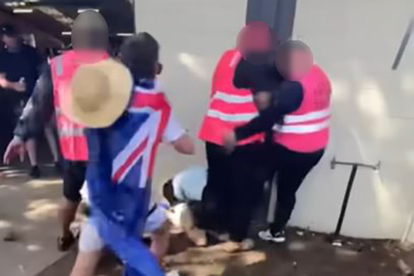Footage shows crowd safety staff surrounding a man on the ground, before one appears to kick him.