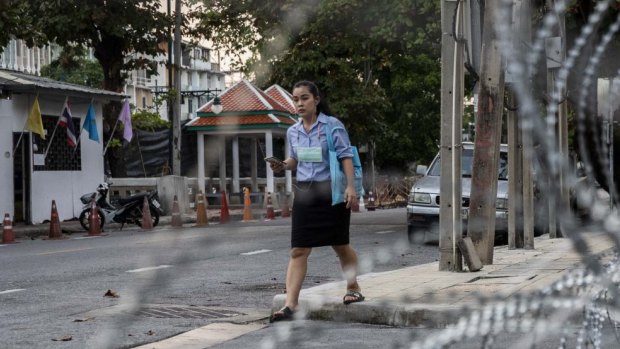 A Thai woman walks in front of the Crown Property Bureau in Bangkok, Thailand.