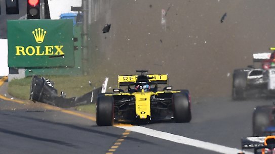 Forced wide: Daniel Ricciardo raises a cloud of detritus and dust on the far left of the pack after impact with turn one obstacle.