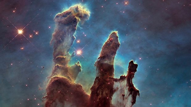 Pillars of Creation in the Eagle Nebula, captured by the Hubble telescope, with hydrogen shown as green. Sulphur is red and oxygen is blue. 