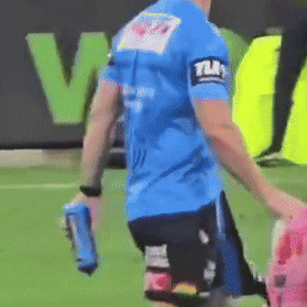 Panthers football manager and blue shirt trainer Shane Elford sprays water on the ball before a golden point kick-off against North Queensland.