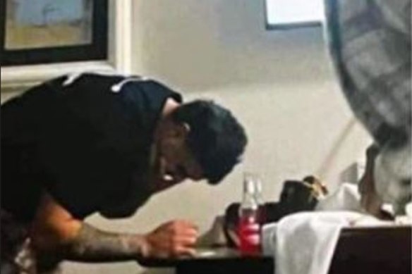 Latrell Mitchell leans over a table with a white substance on it.