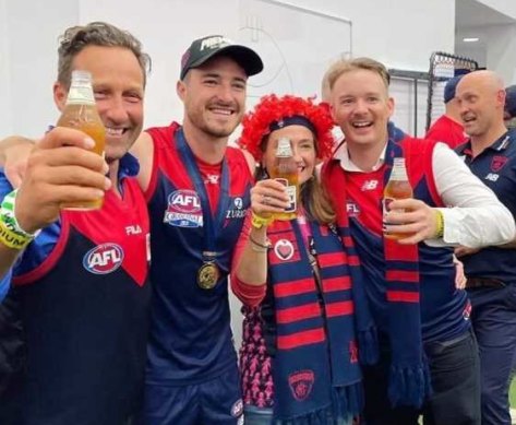 Hayden Burbank (left) inside the AFL rooms after Melbourne’s win at the grand final.