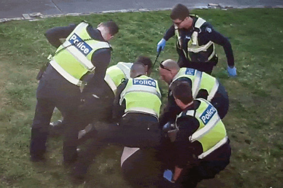 An image from CCTV showing police restraining John outside his Preston home in 2017.
