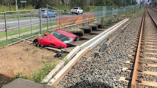 One of several vehicles in the rail corridor, some of which were swept there by floodwaters.