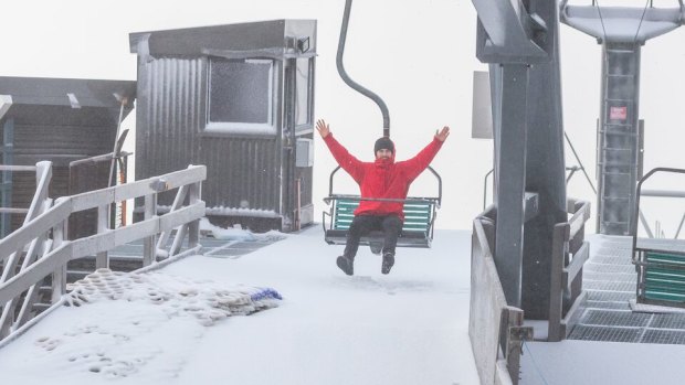 A Thredbo visitor gets ready to ride the chairlift after 5cm of fresh snow fell at the weekend.