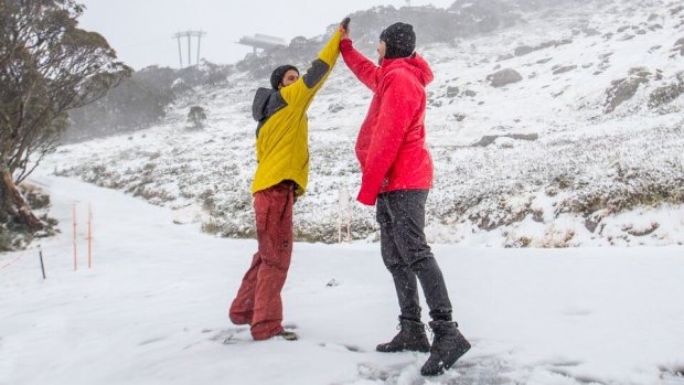Thredbo visitors celebrate 5cm of fresh snow with a high-five.