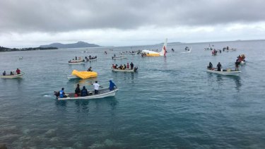 A number of locals in boats ferried passengers from the plane.