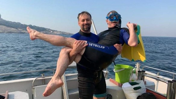 John Mash holds fellow Canadian firefighter Mike May on the trip around Montague Island.