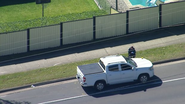 Police examine the white ute at the scene. 
