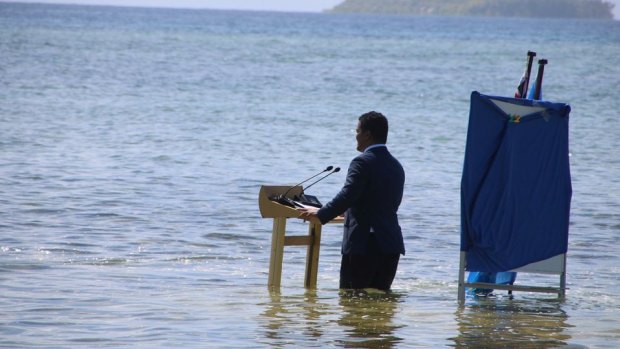 Tuvalu’s Minister for Justice, Communication and Foreign Affairs Simon Kofe gives a COP26 statement while standing in the ocean in Funafuti, Tuvalu, last year.