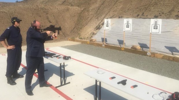Police Minister David Elliott with a submachine gun at the opening of the Corrective Services NSW firing range in 2018.