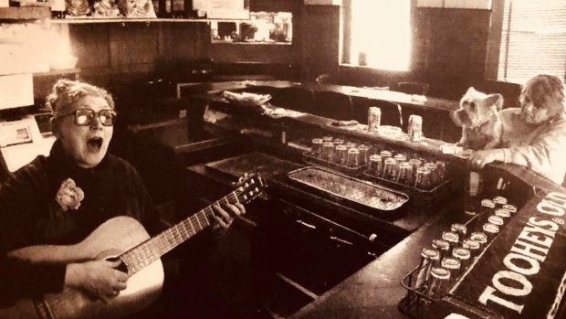 Doris Goddard plays guitar behind the bar at the Hollywood Hotel.