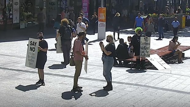 Jonathan Sri (centre, pink shirt) is captured by Queen Street Mall security cameras at the 2020 protest.