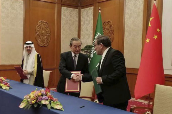 Secretary of Iran’s Supreme National Security Council, Ali Shamkhani, right, shakes hands with China’s most senior diplomat Wang Yi, as Saudi Arabia’s National Security Adviser Musaad bin Mohammed al-Aiban looks on.