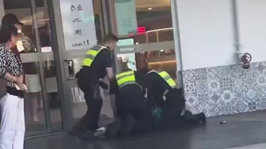 Police officers apprehend a person at Northland after Sunday’s brawl.