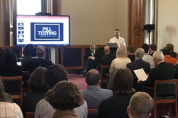 Fiona Patten (back left) and Gino Vumbaca (back right) at the 2019 pill-testing show and tell in front of MPs at Victorian Parliament.