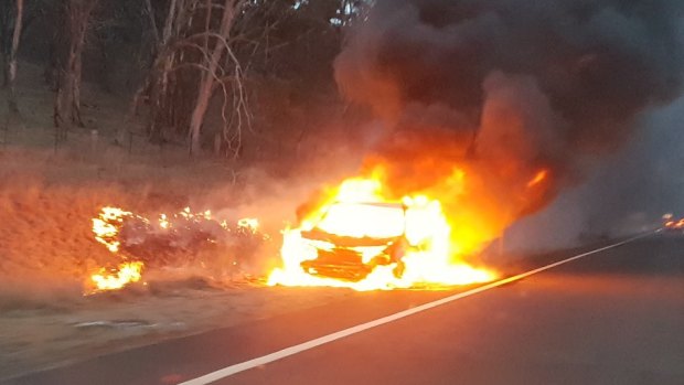 A car burns on the Monaro Highway near Michelago after hitting a kangaroo on Monday morning.