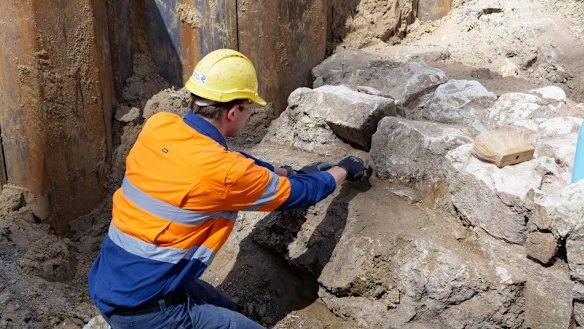 A worker inspects a 30-metre stone wall discovered under Adelaide Street in February 2022.