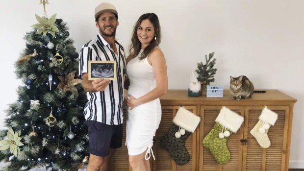 Three stockings hang in the couple’s home for Christmas 2020, as Matt Field holds an ultrasound picture of unborn son Miles.