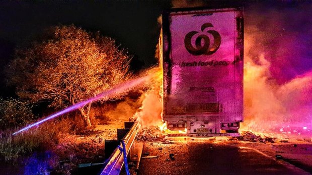 Firefighters work to extinguish a blaze that engulfed a Woolworths truck on the Hume Motorway.