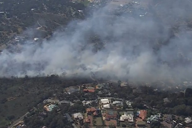 The out-of-control blaze in the Perth Hills is burning close to homes and forced residents to evacuate after emergency warnings were issued across Forrestfield, Kalamunda and Lesmurdie.