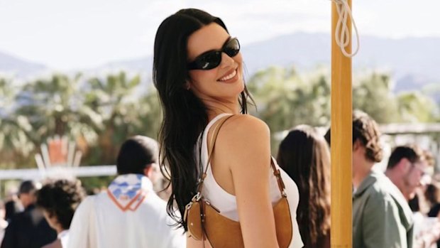 Kendall Jenner in the unofficial Coachella uniform carrying a Kate Spade New York handbag.