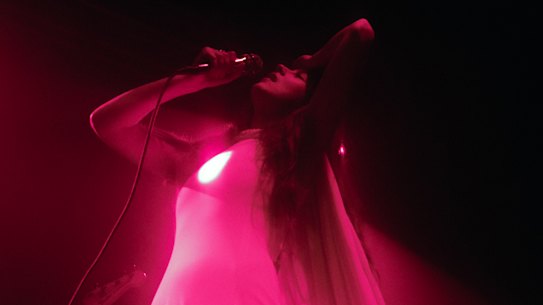 Weyes Blood - with her glowing heart - on stage.