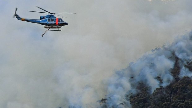 A helicopter waterbombing fires on the NSW South Coast.