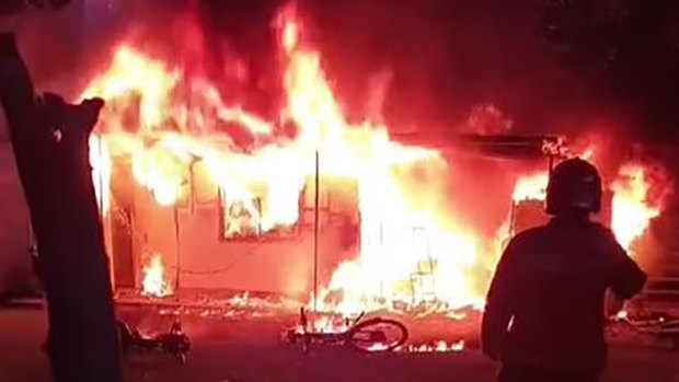 A firefighter surveys the blaze at the Petersham boarding house on Saturday morning. E-bike batteries in the area fuelled the fire’s intensity.