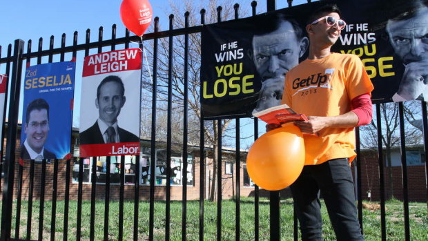 A GetUp! supporter hands out how-to-vote cards in the ACT during the 2013 election.