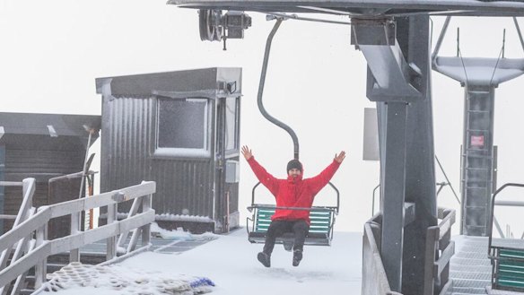 A Thredbo visitor gets ready to ride the chairlift after 5cm of fresh snow fell at the weekend.