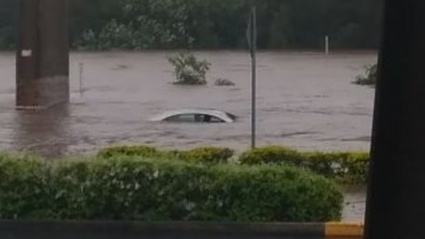 The top of a vehicle can be seen in floodwaters at Toombul.