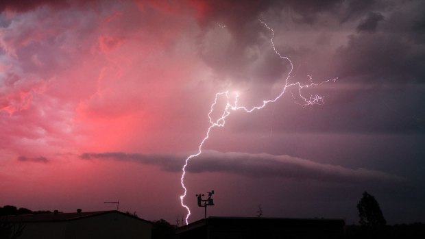 Lightning strikes with the backdrop of a red sky in the Ipswich suburb of Karalee on Wednesday night.