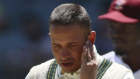 Usman Khawaja leaves the field after being hit on the jaw by a bouncer in Adelaide on Friday.