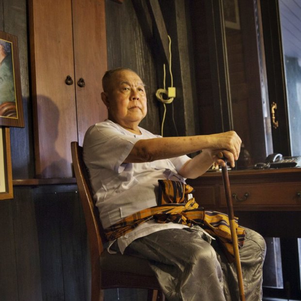 Sulak Sivaraksa, who has been charged or arrested five times under Thailand's lese-majeste law, at home in Bangkok. To the left is a photo of Sulak with the late king, Bhumibol Adulyadej.