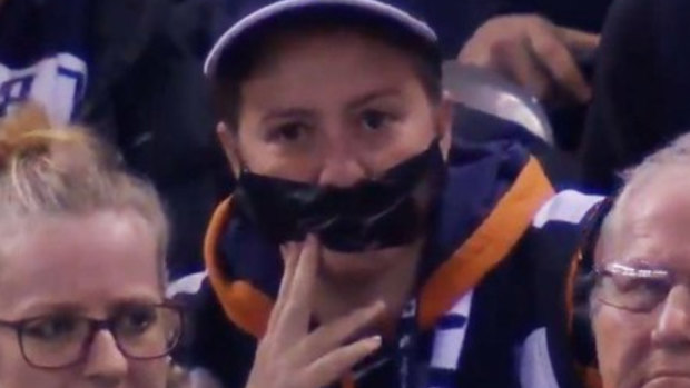 A Carlton fan wears tape over her mouth to protest against the AFL's crowd behaviour measures.
