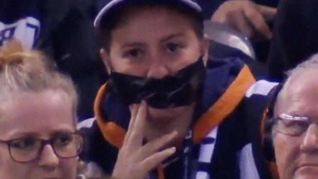 A Carlton fan wears tape over her mouth to protest against the AFL's crowd behaviour measures.