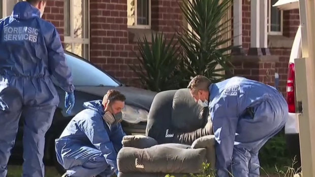 Police collect evidence from the Cambridge Park home where a woman's body was found on Tuesday.