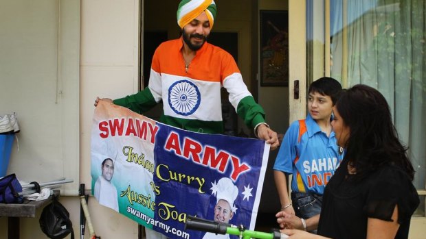 Gurnam Singh shows his sister Manjeet Bailie and nephew Rajeer Singh the banner he made for the "Swami army".