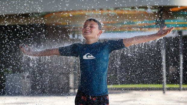 Hudson Battersby, 11, from Brassall, plays under the water curtain at Tulmur Place in Ipswich's Nicholas Street Precinct.