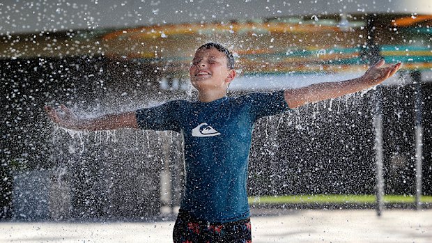 Hudson Battersby, 11, from Brassall, plays under the water curtain at Tulmur Place in Ipswich's Nicholas Street Precinct.