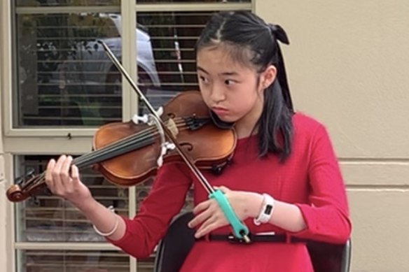 Tiana Ekpanyaskun playing her adapted violin.