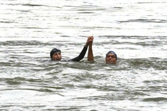 Amelie Oudea-Castera (left) and Alexis Hanquinquant, a triathlon gold medallist from the Tokyo Paralympics, in the Seine on July 13.