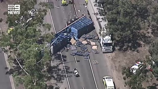 Henry Lawson Drive is closed in both directions at Milperra following a crash involving two trucks and a car.