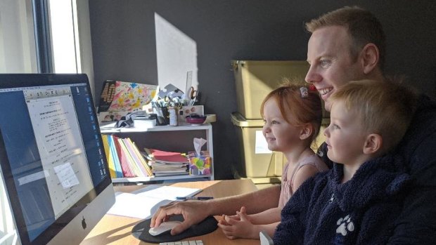 Television writer Tim Bain working from home with his two children. 