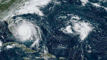 Hurricane Dorian, left, churning over the Bahamas.